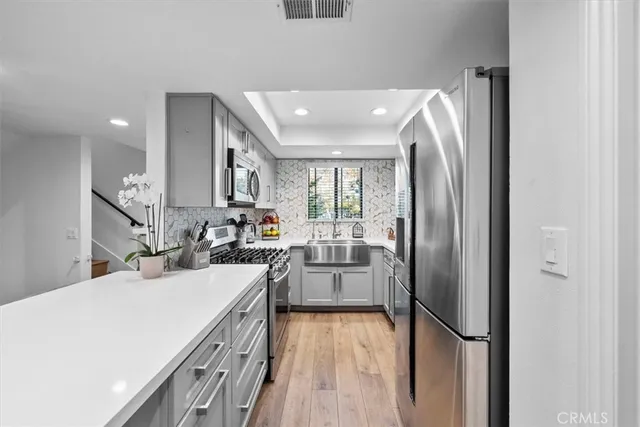 a kitchen with kitchen island stainless steel appliances a dining table and chairs in it
