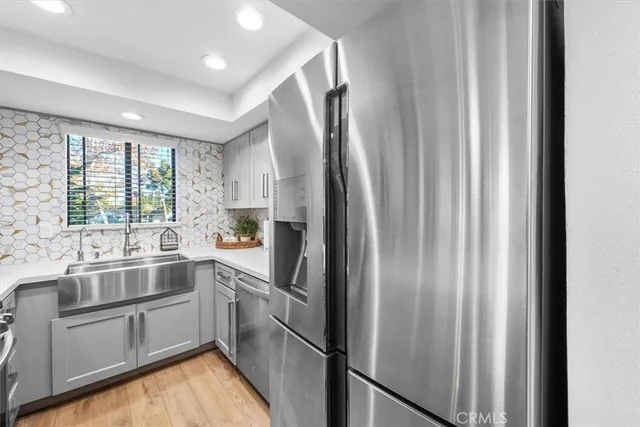 a kitchen with kitchen island a appliances dining table and wooden floor