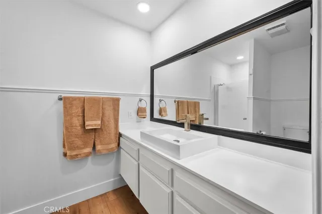 a bathroom with a double vanity sink toilet and shower