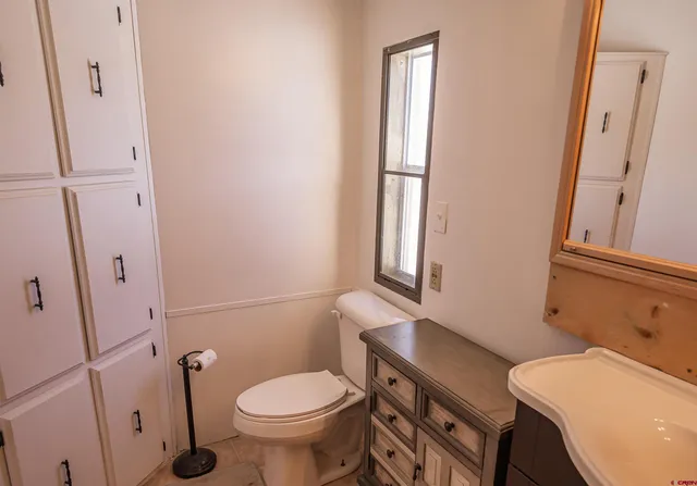 a bathroom with a sink a toilet a mirror and shower