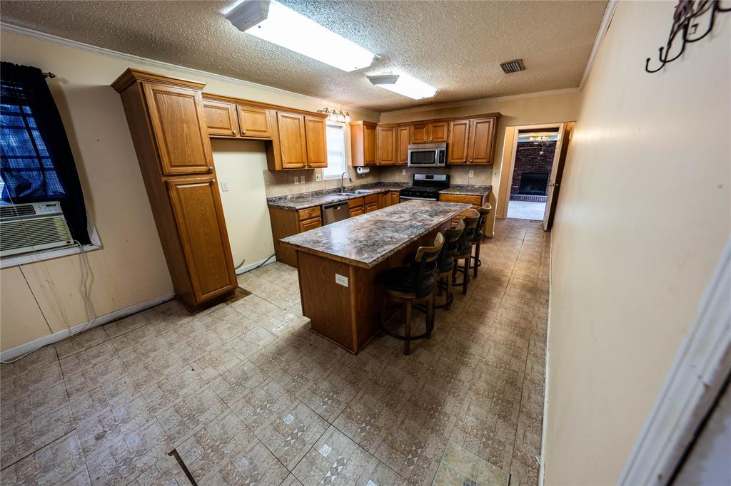 7341 Broadacres Road Shreveport, LA 71129 - Photo 10 of 23 a kitchen with stainless steel appliances granite countertop a refrigerator a sink a stove a microwave and island