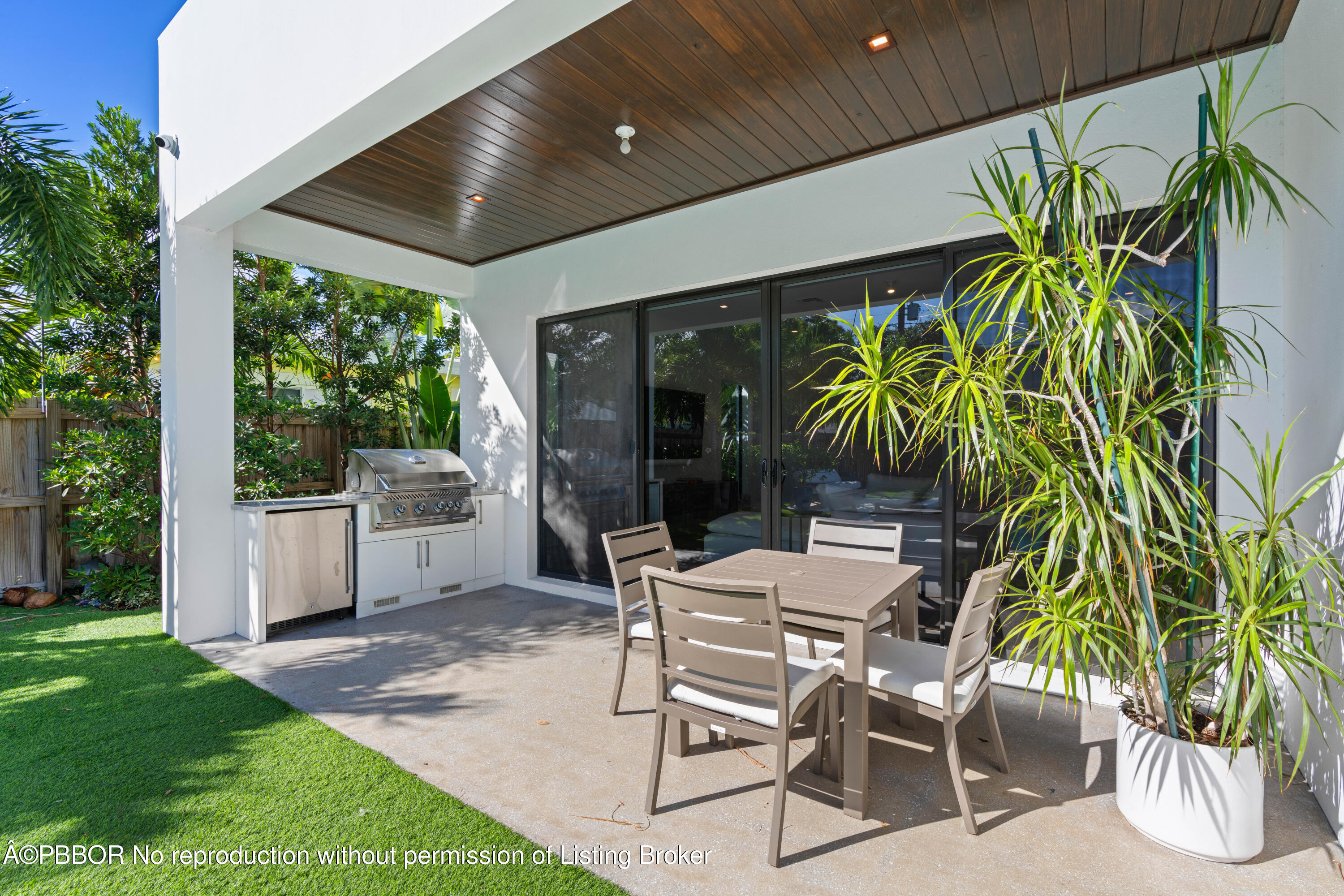 230 Seville Road West Palm Beach, FL 33405 - Photo 8 of 25 a patio with a table and chairs and potted plants