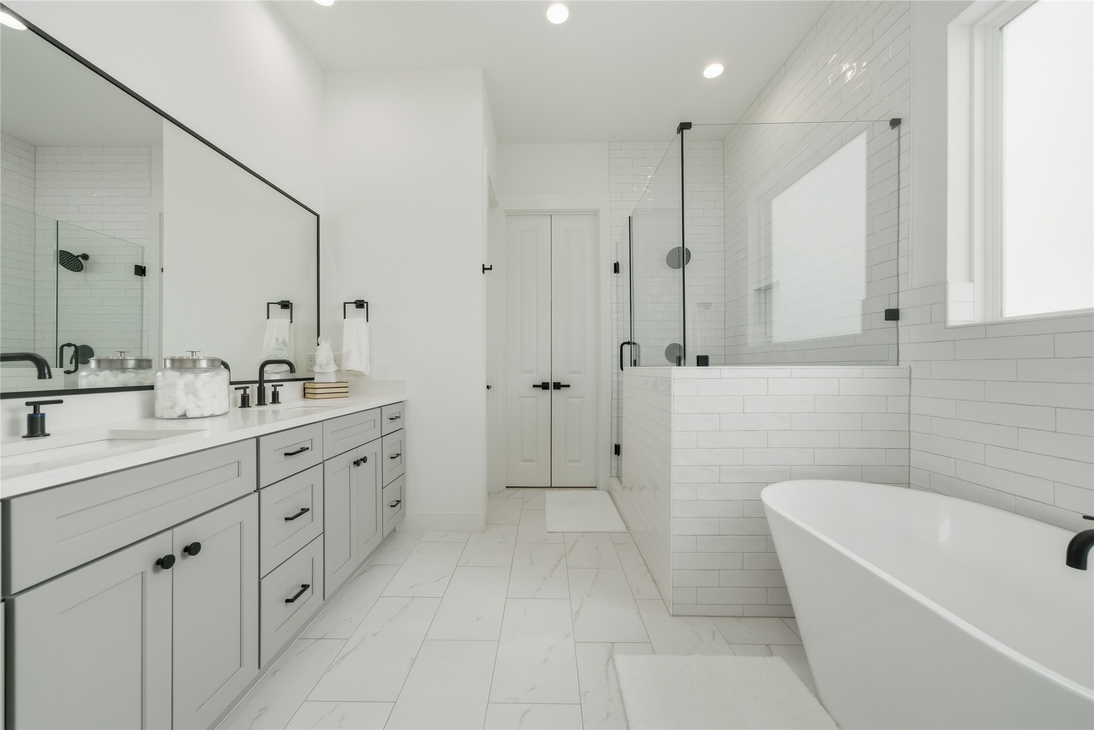 1307 East 27th Street Houston, TX 77009 - Photo 17 of 33 a bathroom with a double vanity sink a large mirror and a bathtub