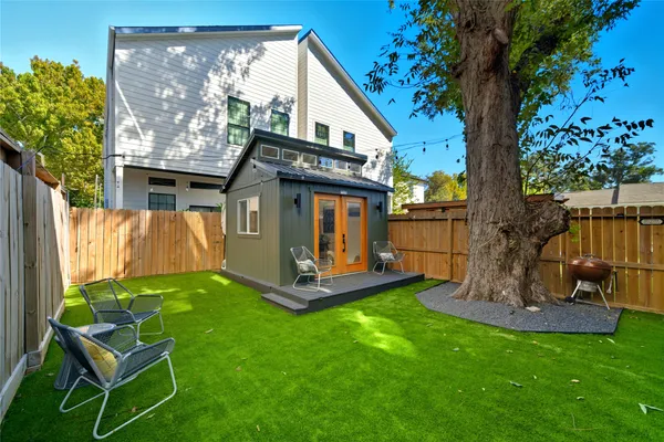 a view of a chair and table in backyard of the house