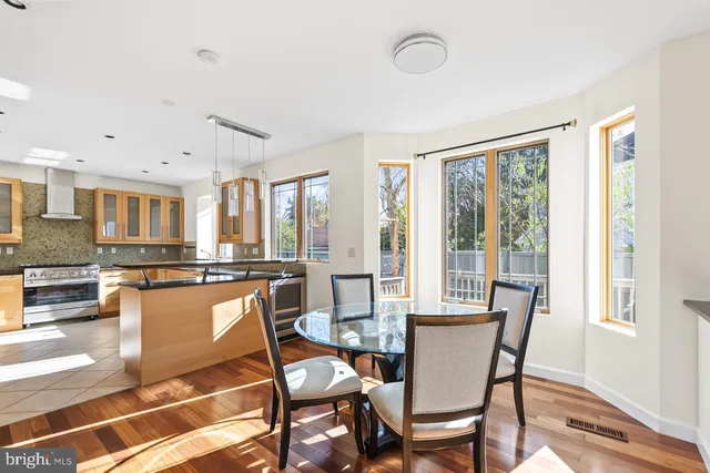 a kitchen with stainless steel appliances granite countertop a refrigerator a stove and a sink with wooden floor