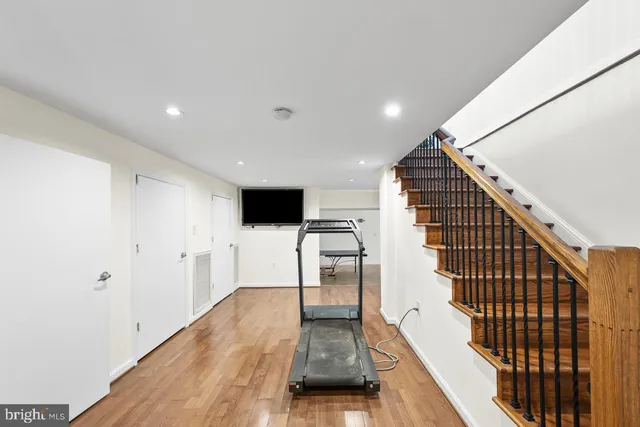 a view of a white house with a large window and wooden fence