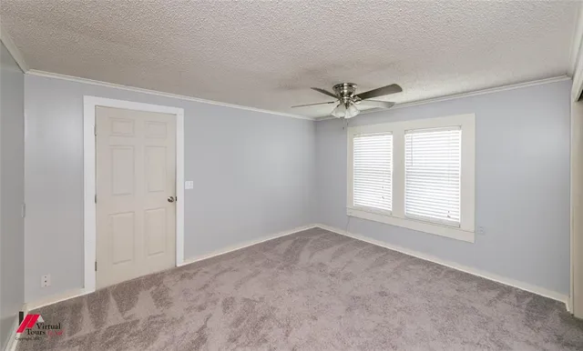 a view of an empty room with a ceiling fan and a window