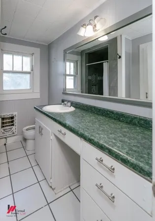 a bathroom with a granite countertop sink mirror vanity and window