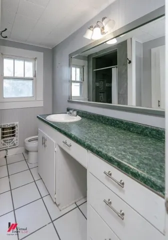 a bathroom with a granite countertop sink mirror vanity and window
