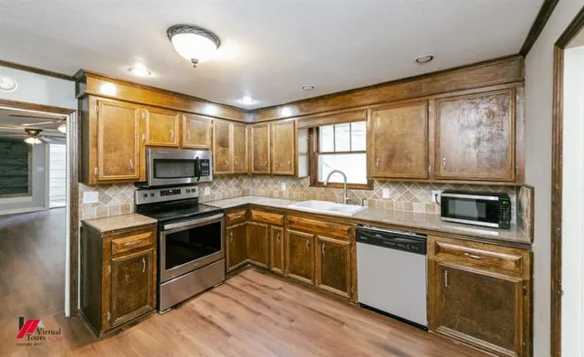a kitchen with stainless steel appliances granite countertop a stove a sink and a microwave