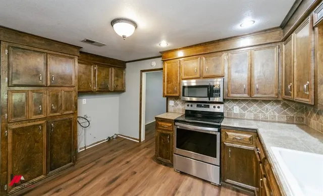 a kitchen with stainless steel appliances and wooden cabinets