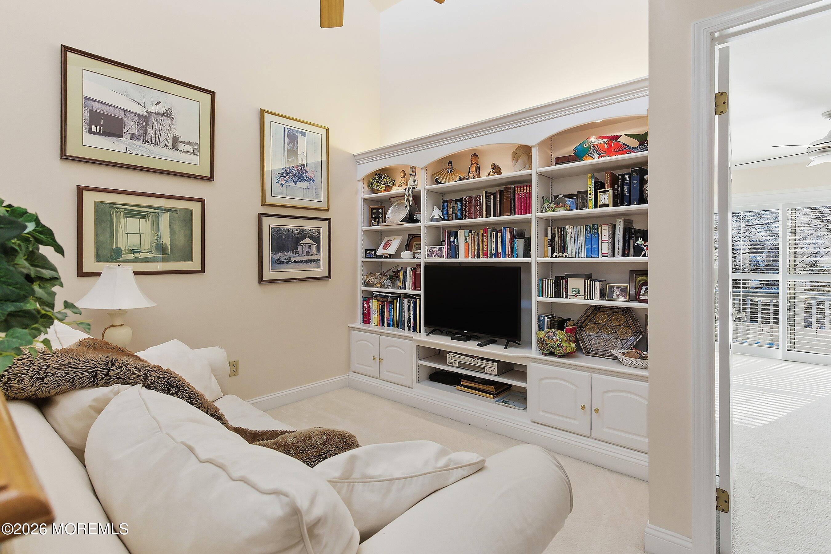 29 Rambling Meadow Court Tinton Falls, NJ 07724 - Photo 22 of 29 a living room with furniture a rug and a bookshelf