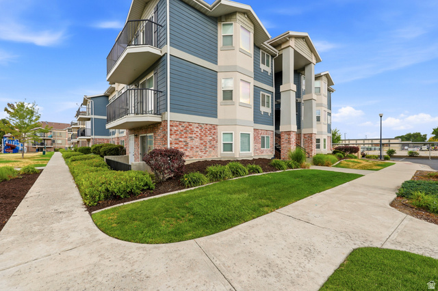 116 East Resaca Drive, Unit F6 Sandy, UT 84070 - Photo 5 of 32 Multi-story building featuring blue siding, red brick veneer, and individual balconies with black metal railings