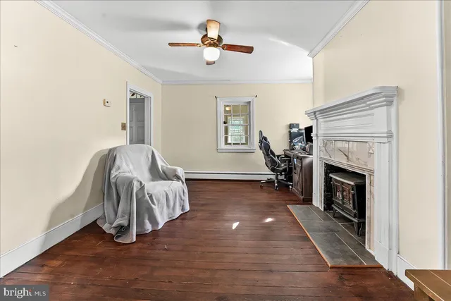 a living room with a fireplace furniture a ceiling fan and a rug