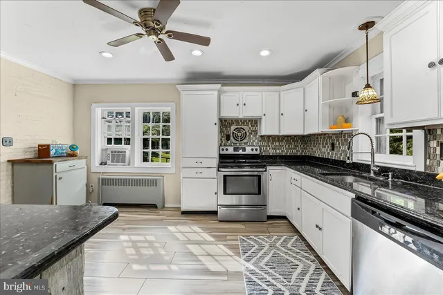 a kitchen with stainless steel appliances granite countertop a stove sink and cabinets