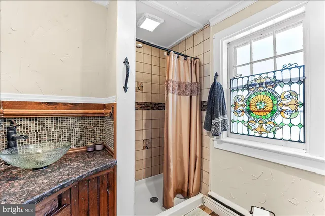 a bathroom with a granite countertop sink and a shower