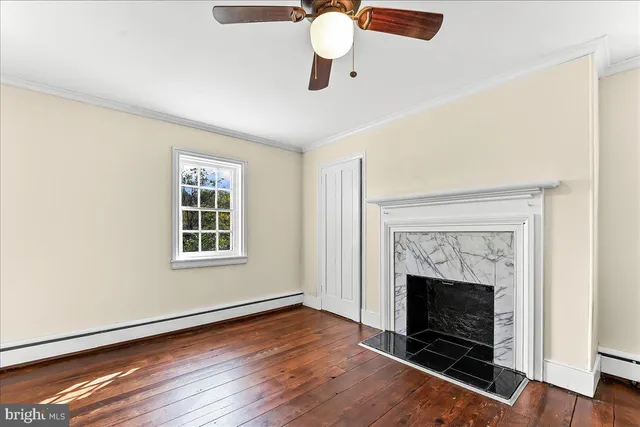 an empty room with windows and fireplace