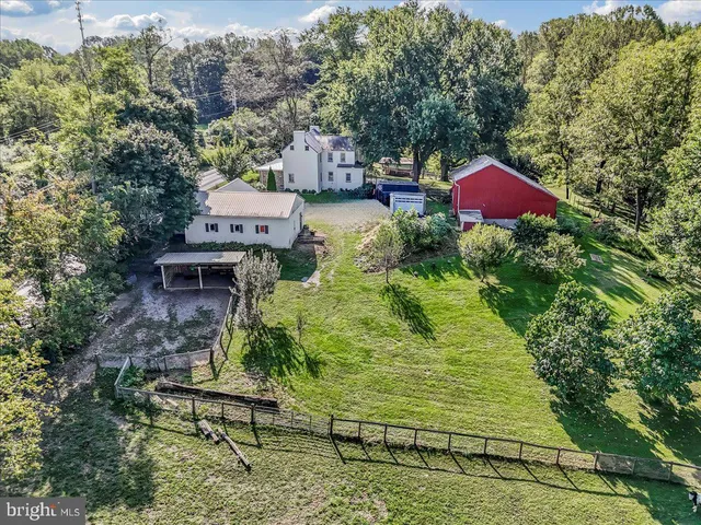 an aerial view of a house with large trees