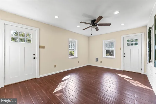 a view of empty room with wooden floor and ceiling fan