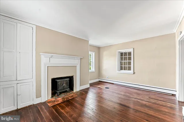 a view of empty room with wooden floor and fireplace