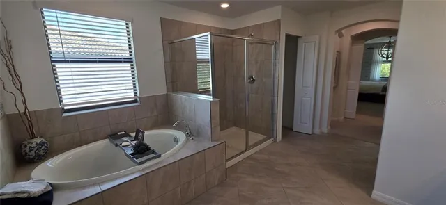 a bedroom with a bed a chandelier and dresser