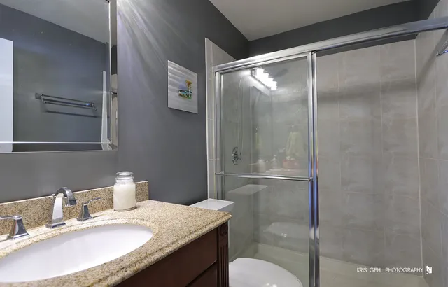 a bathroom with a granite countertop sink toilet and shower
