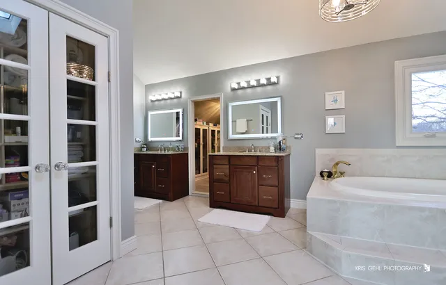 a spacious bathroom with a tub sink and mirror