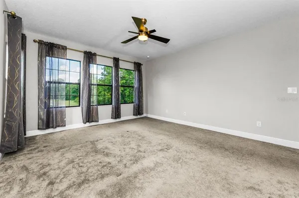an empty room with closet and a ceiling fan