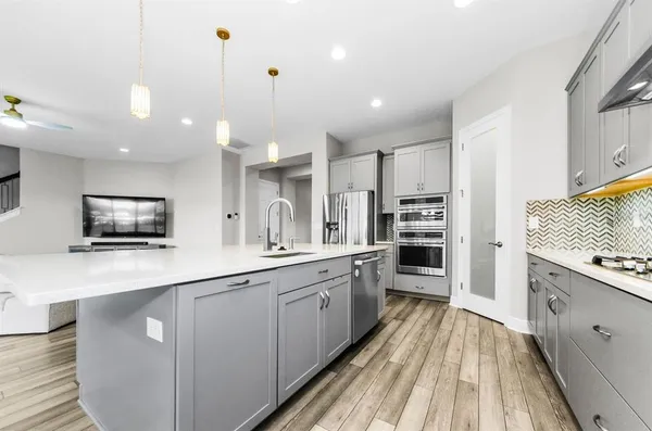 a kitchen with kitchen island a sink and a stove with wooden floor