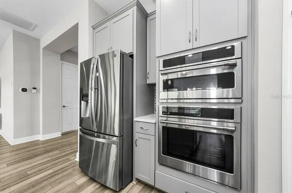a kitchen with white cabinets and stainless steel appliances