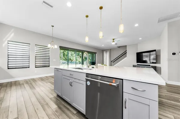 a kitchen with stainless steel appliances granite countertop a sink a stove and cabinets