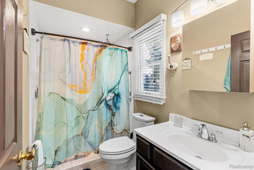 1476 County Farm Road Howell, MI 48843 - Photo 11 of 53 Bathroom with vanity, tile patterned floors, and a shower with curtain