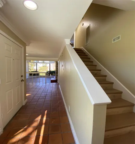 a view of a hallway with wooden floor and staircase