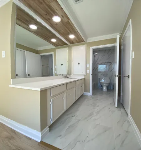 a spacious bathroom with a granite countertop sink and a mirror