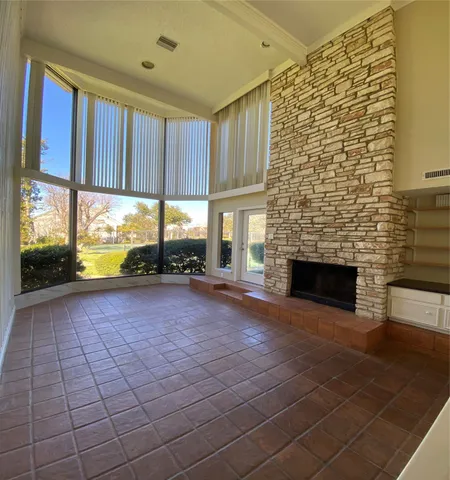 a view of an empty room with a fireplace and a window