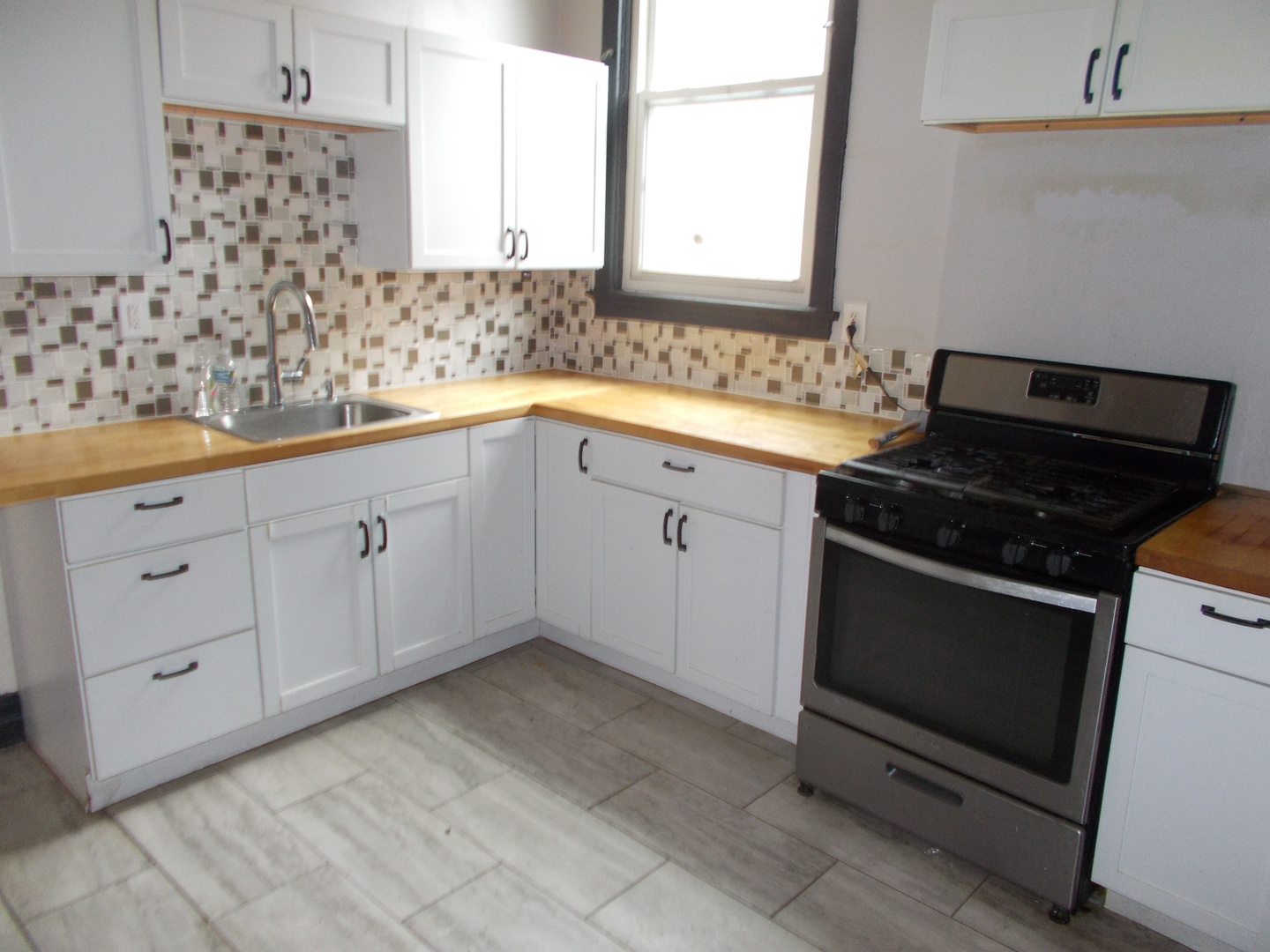5715 South Sangamon Street, Unit 2 Chicago, IL 60621 - Photo 4 of 9 a kitchen with granite countertop white cabinets and appliances