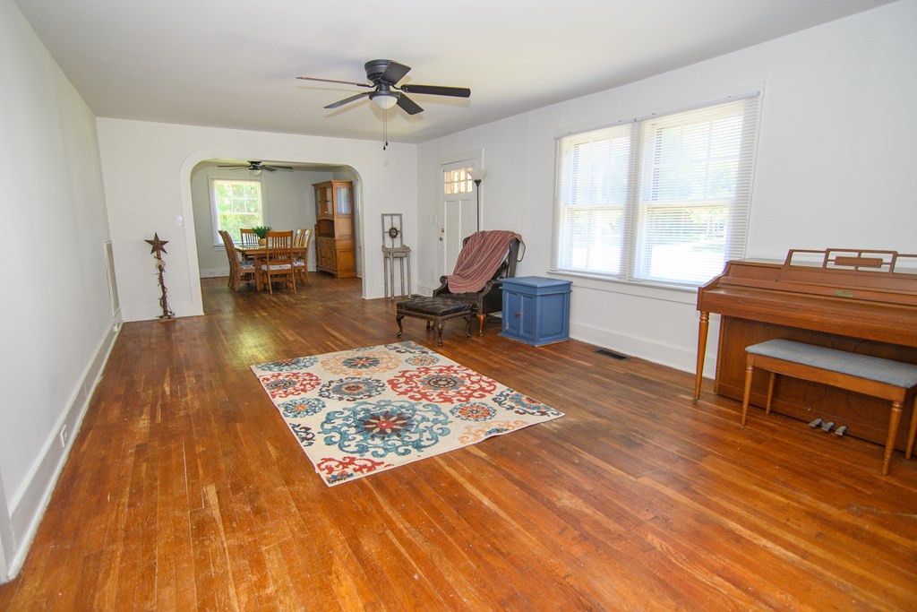 24432 Maxwell Street Parksley, VA 23421 - Photo 14 of 39 a living room with a rug dresser furniture and a wooden floor