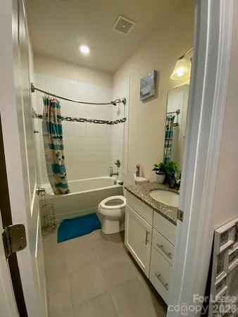 a bathroom with a double vanity sink a toilet a mirror and shower