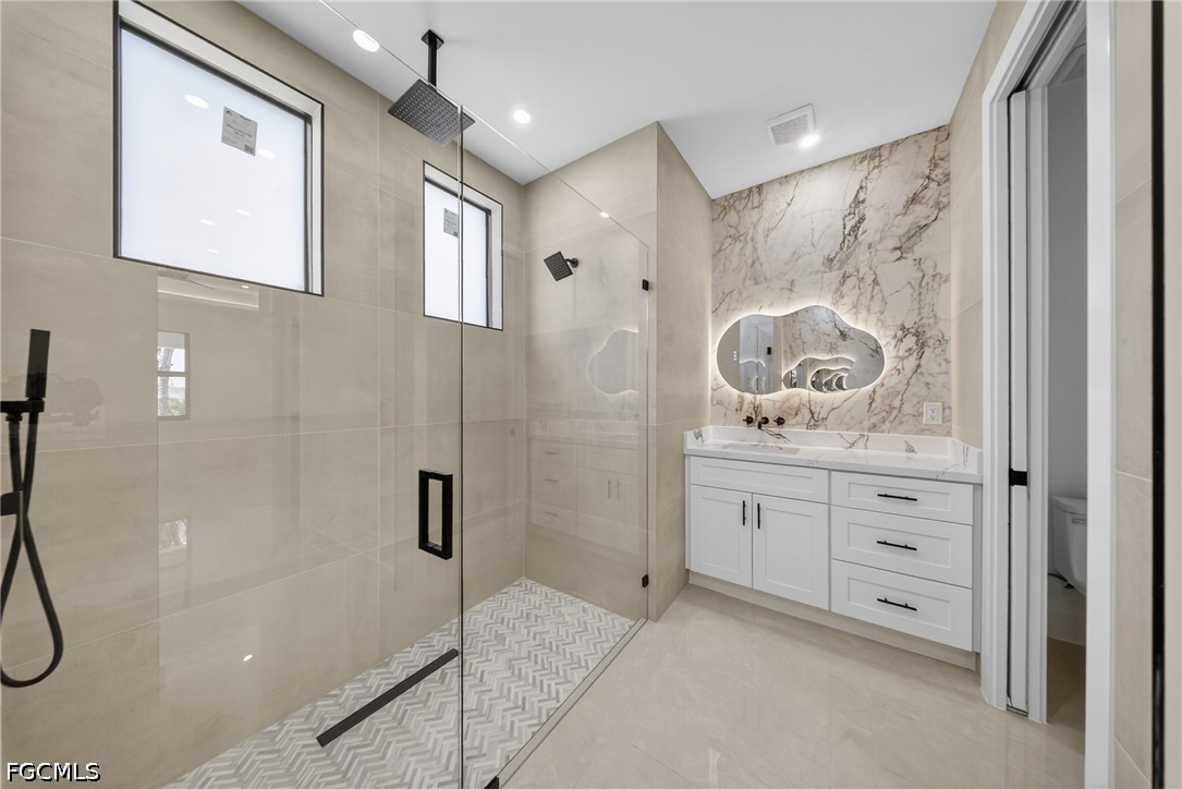4213 25th Street Southwest Lehigh Acres, FL 33976 - Photo 21 of 47 a spacious bathroom with a granite countertop sink a shower and a mirror