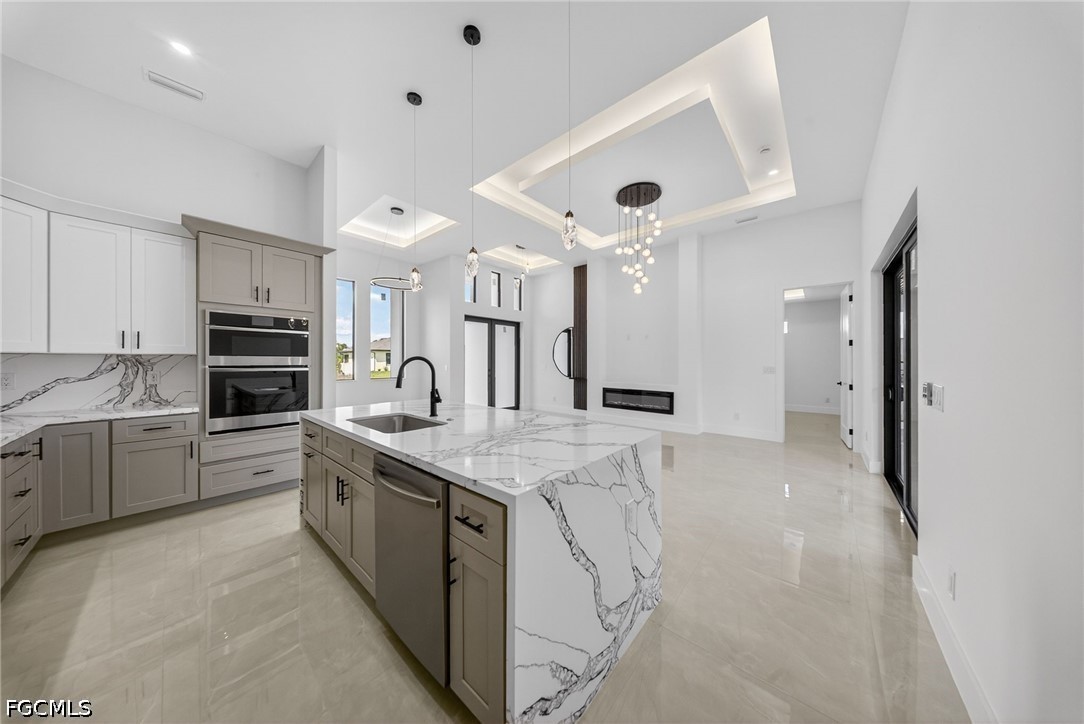 4213 25th Street Southwest Lehigh Acres, FL 33976 - Photo 22 of 47 a large kitchen with kitchen island a sink stainless steel appliances and cabinets
