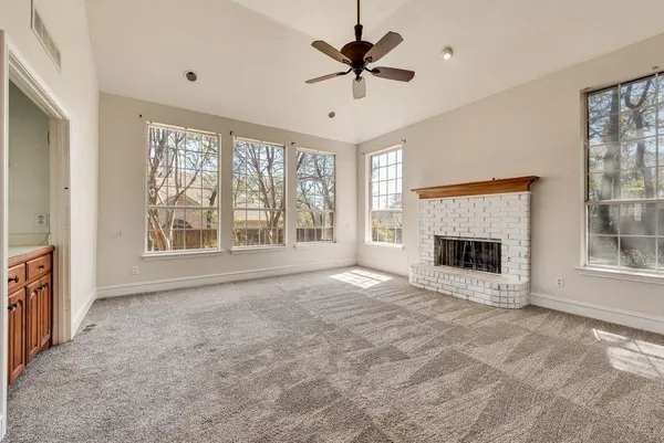 a view of an empty room with a fireplace and a window