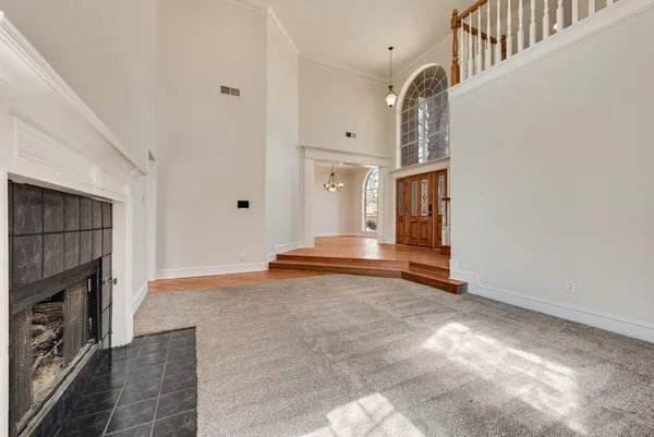 a view of an empty room with staircase and a fireplace
