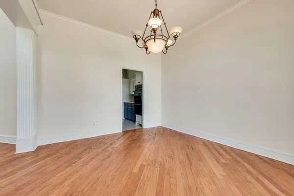 a view of a room with wooden floor and chandelier