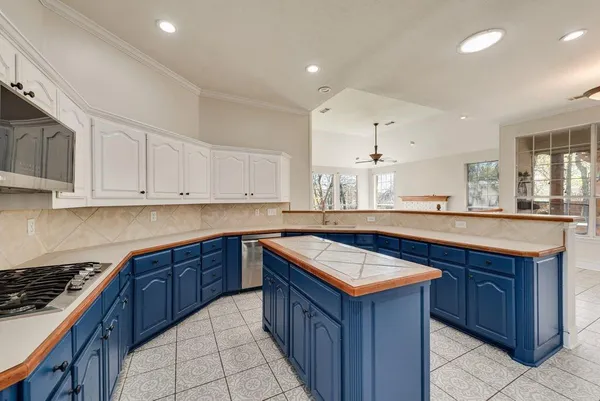 a kitchen with kitchen island granite countertop a sink stove and cabinets