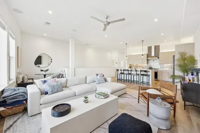 a living room with furniture kitchen view and a table