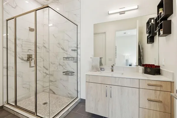 a bathroom with a shower sink and mirror