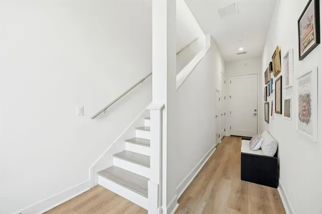 a view of entryway and hall with wooden floor