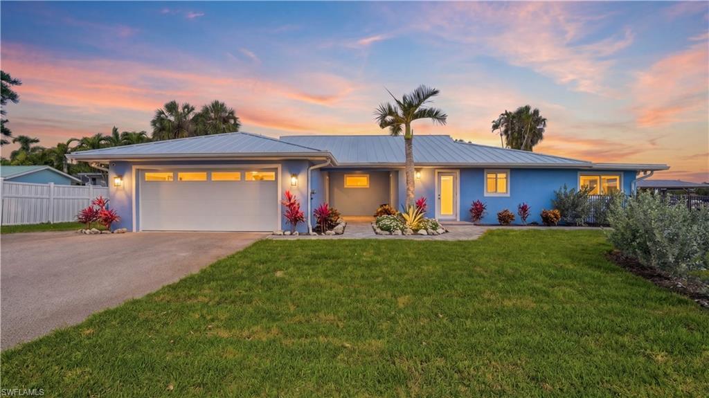 8009 Lagoon Road Fort Myers Beach, FL 33931 - Photo 2 of 48 Front of home with evening lighting