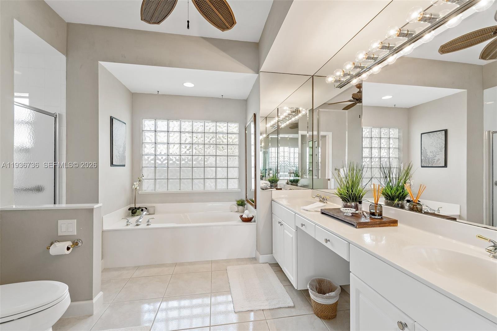 8185 Southeast Double Tree Drive Hobe Sound, FL 33455 - Photo 21 of 40 a spacious bathroom with a bathtub shower sink vanity mirror and toilet