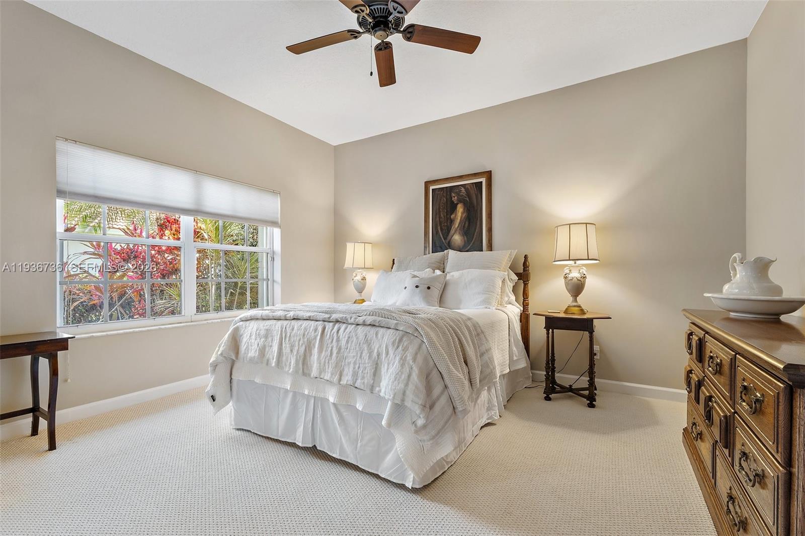 8185 Southeast Double Tree Drive Hobe Sound, FL 33455 - Photo 25 of 40 a spacious bedroom with a bed and a chandelier